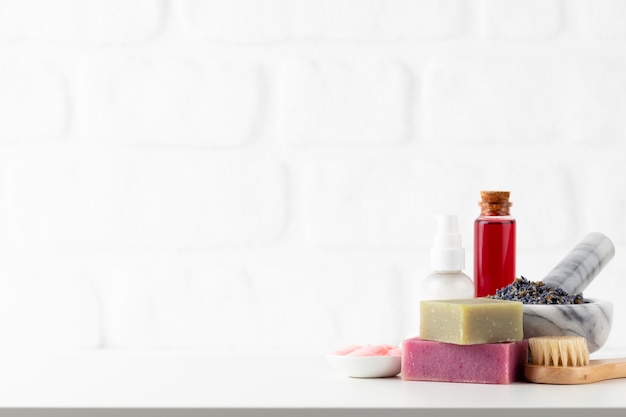 Cosmetics bottles and natural handmade soap on white background