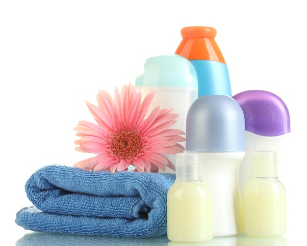 Cosmetics bottles with towel and flower isolated on white