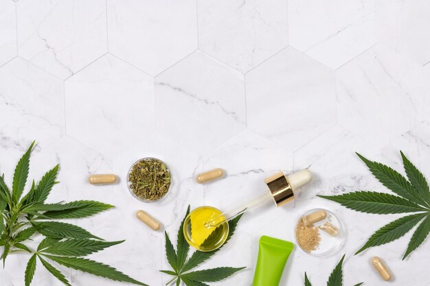 Cosmetics CBD oil hemp powder capsules dry tea and green cannabis sativa leaves top view Mockup