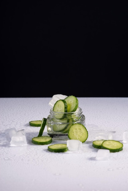 Cosmetics cucumber with ice on black and white background