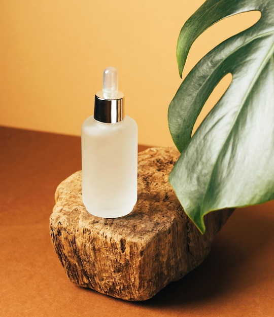 Cosmetics serum oil bottle modern podium of natural colors tropical plant leaf