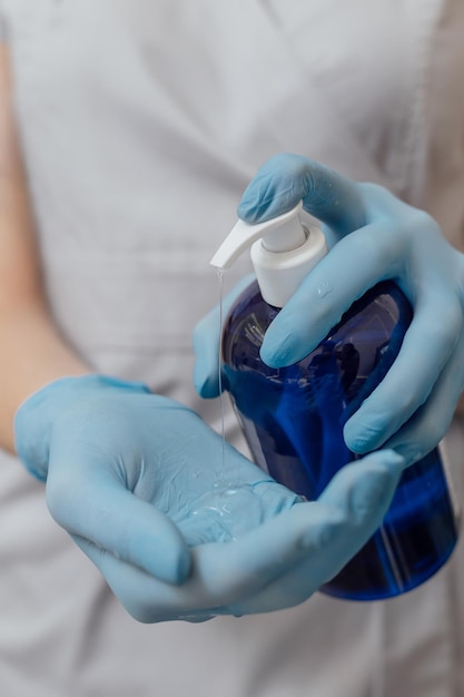 Cosmetics or skin care product in dark blue bottle in beautician hands