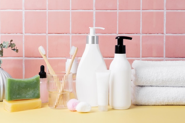 Cosmetics skincare beauty products and cotton towels set of cosmetics bottles on table inside a bathroom wall tiles ceramic background