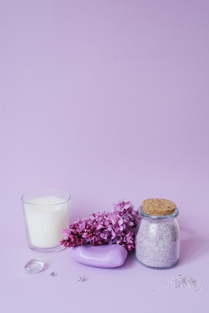 Cosmetics soap and bath salts and lilac flowers on the background an even layer Copy space