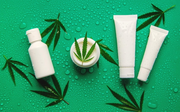 Cosmetics with cannabis extract on a wet background Selective focus