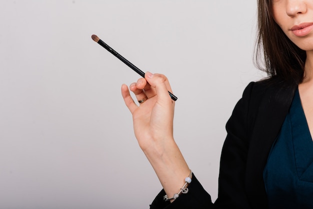 Cosmetologist beautician holding a tool in her hands, permanent makeup master, permanent makeup, tattoo pen, close up