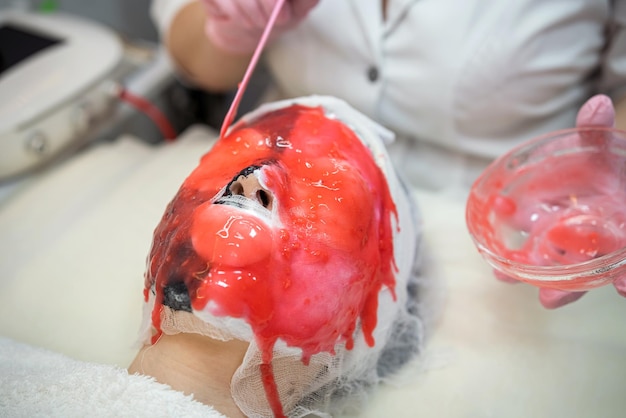 Cosmetologist doing procedure with alginate mask for antiaging treatment face her female client