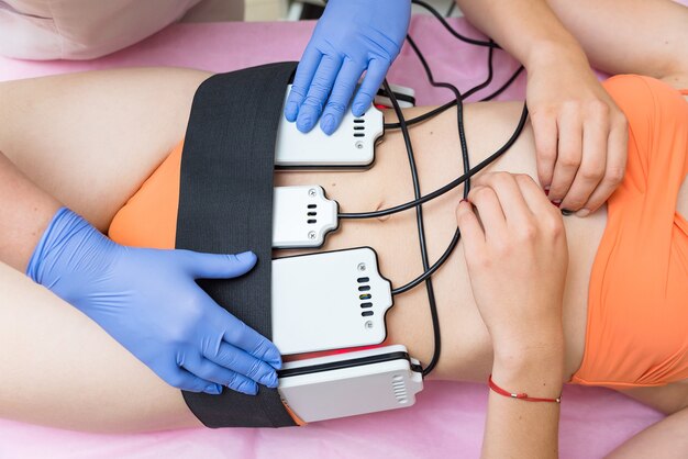 The cosmetologist installs the massage machine on the client