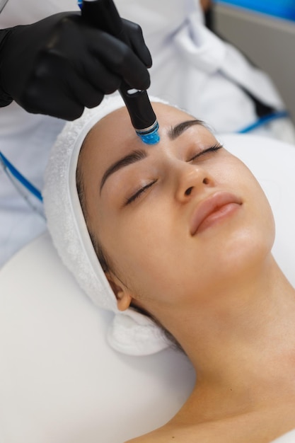 Cosmetologist making mesotherapy injection with dermapen on face for rejuvenation on the spa center