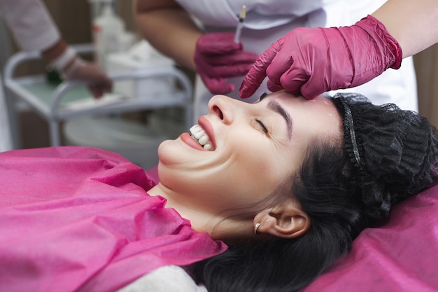 Cosmetologist preparing to do an antiaging injection. Woman on cosmetology procedure