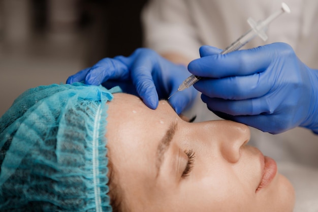 Cosmetologist preparing patient for botox procedure