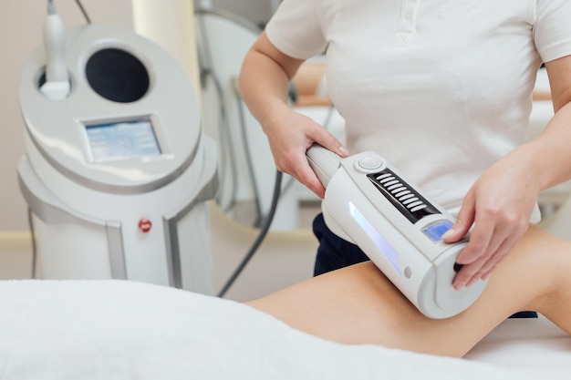 Cosmetologist using endospheres therapy machine on a female