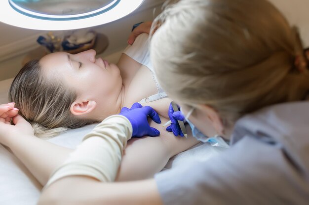 In the cosmetology room the master performs the procedure for permanently removing unwanted hair with the help of electrolysis