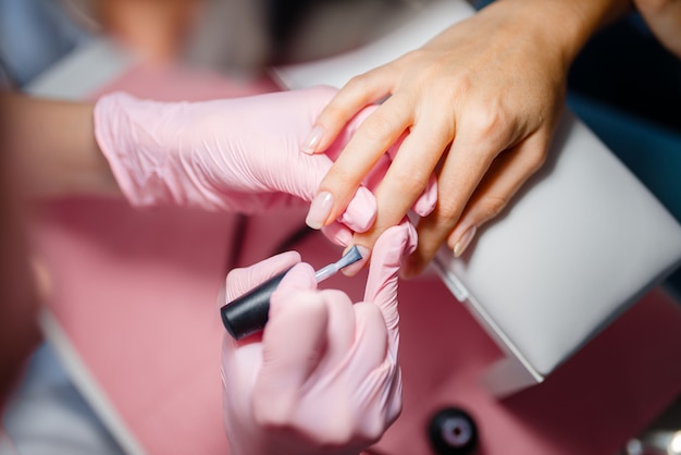 Cosmetology salon, manicure, varnish application procedure.