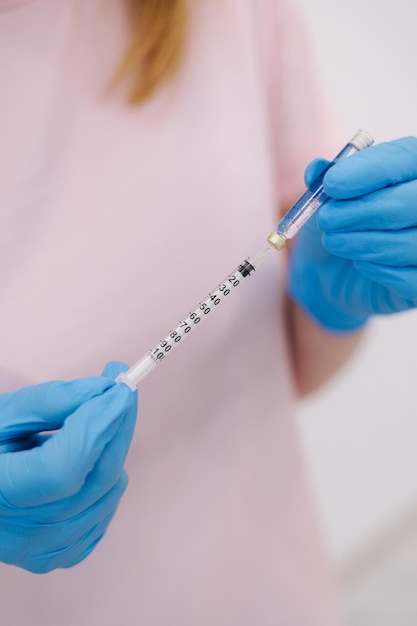 Cosmetoloist injectionist hold syringe in hands closeup