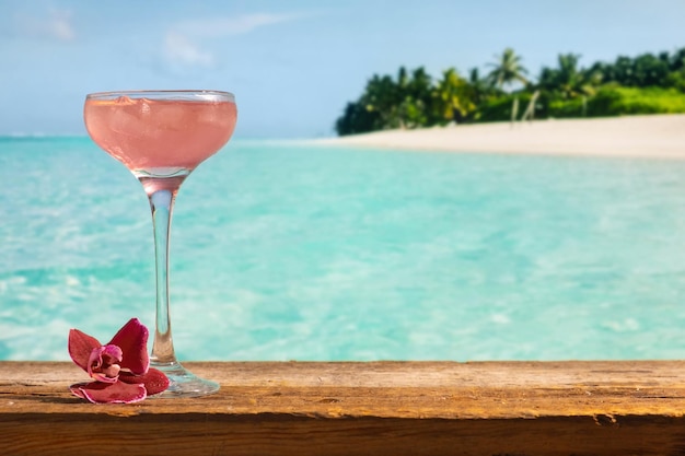 Cosmopolitan pink alcoholic cocktail Glass of summer cocktail on tropical beach bar