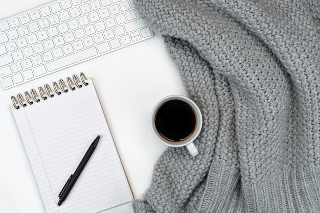 Cosy working writing place with warm sweater coffee, notepad