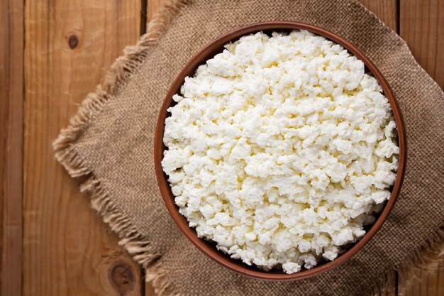 Cottage cheese on a burlap Fresh cottage cheese in a bowl Soft cheese on a wooden boards