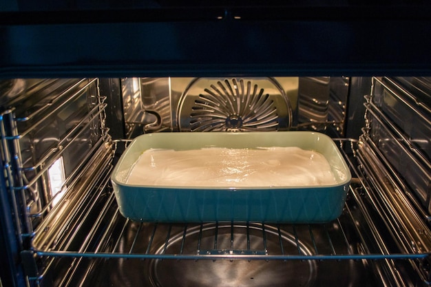 Cottage cheese casserole with raspberries and hazelnuts in a glass form is baked in the oven Closeup