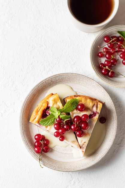 Cottage cheese casserole with summer berries on white table Top view text space