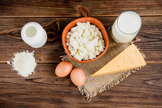 Cottage cheese, cheese and glass of milk on wooden background. Dairy products.