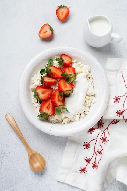 Cottage cheese, curd cheese with strawberries berries in a bowl, ogranic homemade dairy product. Healthy dairy product rich in Calcium and Protein.