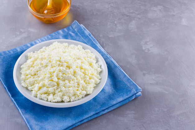 Cottage cheese and honey on concrete Fresh cottage cheese on blue napkin Copy space