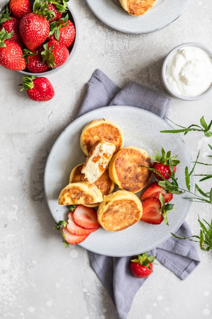 Cottage cheese pancakes or fritters with strawberry and natural yogurt