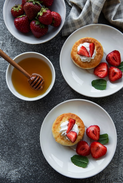 Cottage cheese pancakes ricotta fritters on ceramic plate with  fresh strawberry