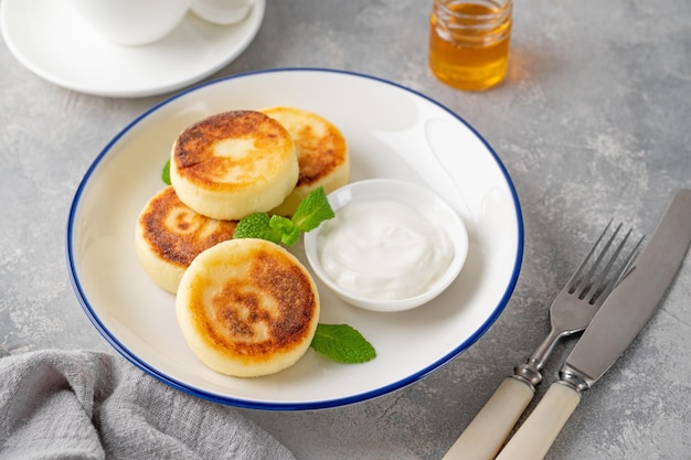 Cottage cheese pancakes syrniki ricotta fritters with honey and sour cream