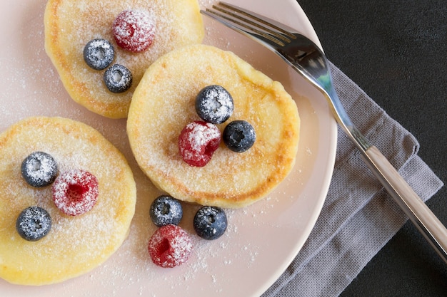 Cottage cheese pancakes, syrniki with fresh berries for breakfast