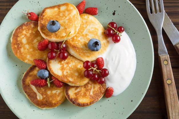 Cottage cheese pancakes, syrniki with fresh berries for breakfast