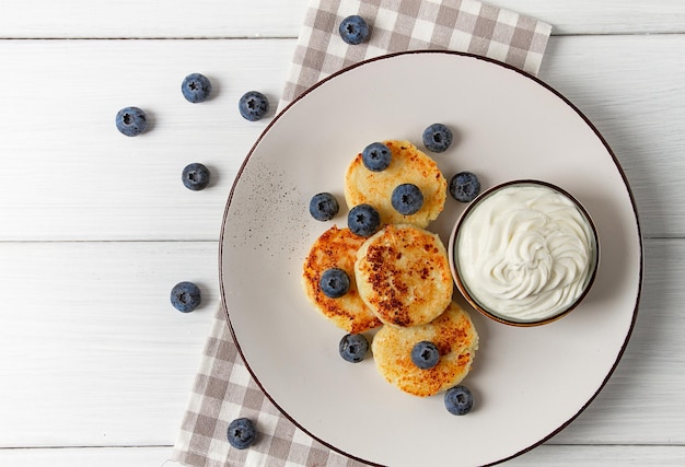 Cottage cheese pancakes with blueberries breakfast on a white wooden table no people top view