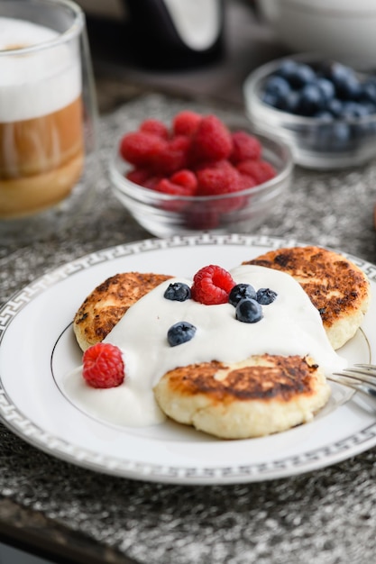 Cottage cheese pancakes with blueberries and raspberries and sour cream