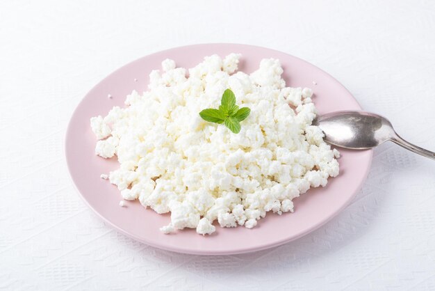 Cottage cheese in a pink plate isolated on a white background