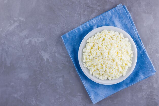 Cottage cheese on plate Fresh cottage cheese in white plate on gray background