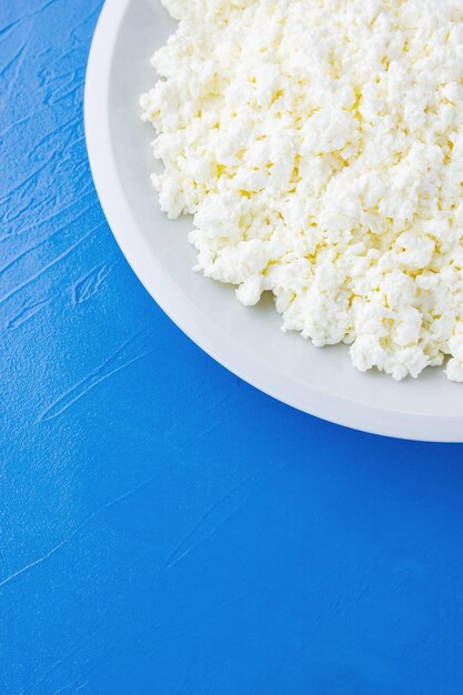 Cottage cheese in a white plate on a blue background Organic eco healthy meal dairy product