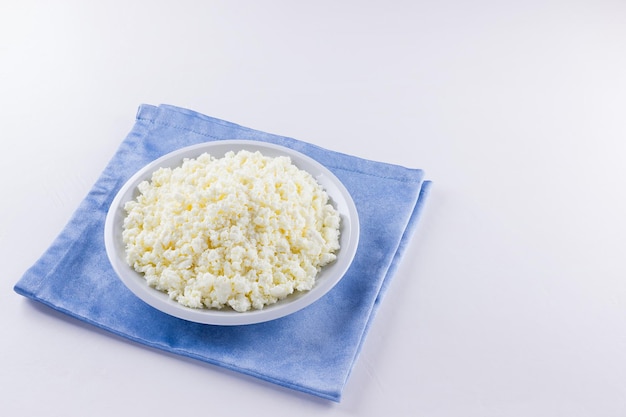 Cottage cheese on white plate Fresh cottage cheese on white background Top view Copy space