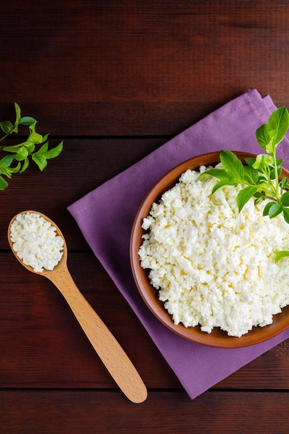 Cottage cheese on wooden boards Fresh cottage cheese in a ceramic bowl Soft cheese and wooden spoon