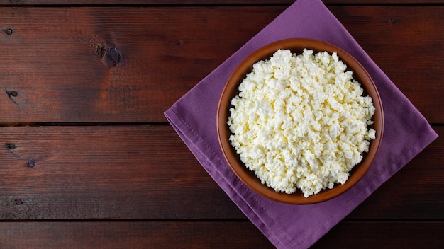 Cottage cheese on wooden boards Fresh cottage cheese in a ceramic bowl