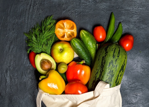 Cotton bag with vegetables and fruits. Flat food was on the table.