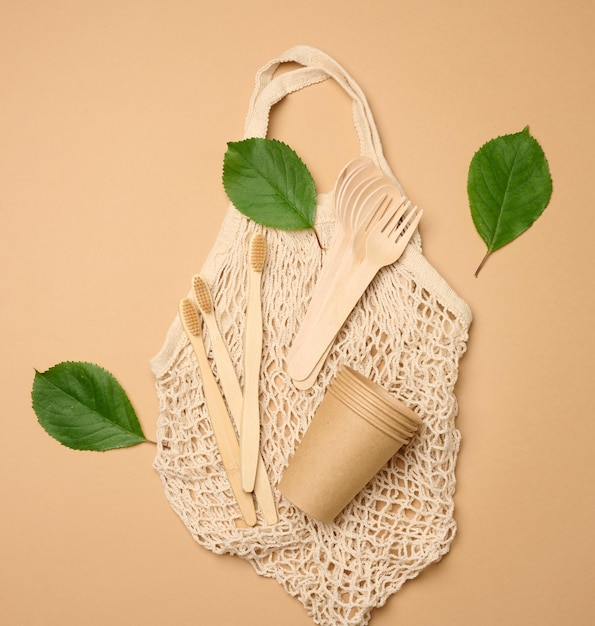 Photo cotton bag wooden spoon cups on a brown background waste recycling concept