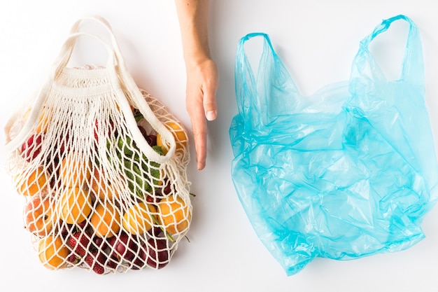 Cotton eco mesh bag with seasonal organic fruits on white background. Eco-friendly concept