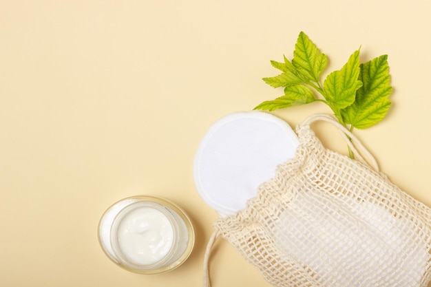 Cotton reusable makeup remover pads in a cloth bag on a beige background The concept of ecology and conscious consumption Reusable cotton pads