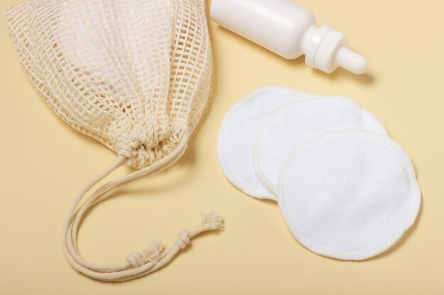 Cotton reusable makeup remover pads in a cloth bag on a beige background The concept of ecology and conscious consumption Reusable cotton pads