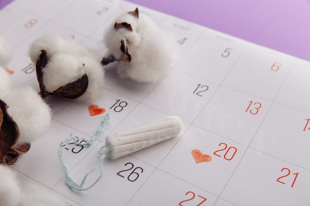 Cotton tampon on a calendar. Hygiene protection for woman critical days