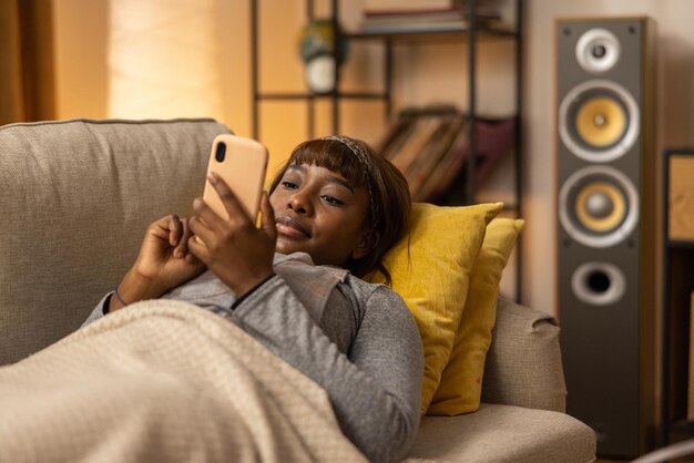 On the couch lies a happy girl who has managed to book a seat at the cinema online