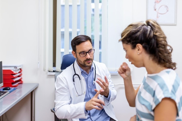 Coughing woman visiting doctor at clinic patient coughing at medical appointment with her doctor Sick woman visiting doctor at the hospital