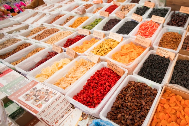 Countertop with a variety of dried fruits candied fruit and nuts in containers background