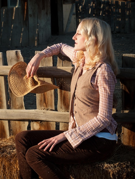 Country girl sitting by the fence.